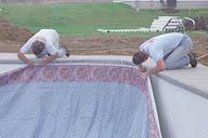 The custom-fit vinyl liner is installed into the coping track.
